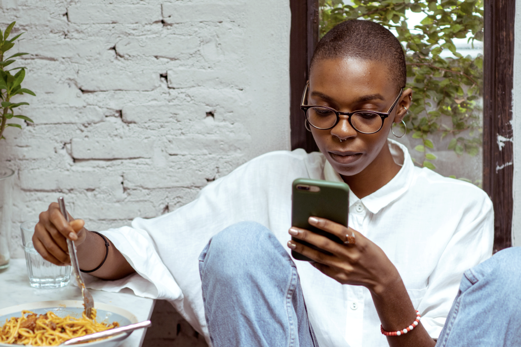 Person eating dinner looking at phone