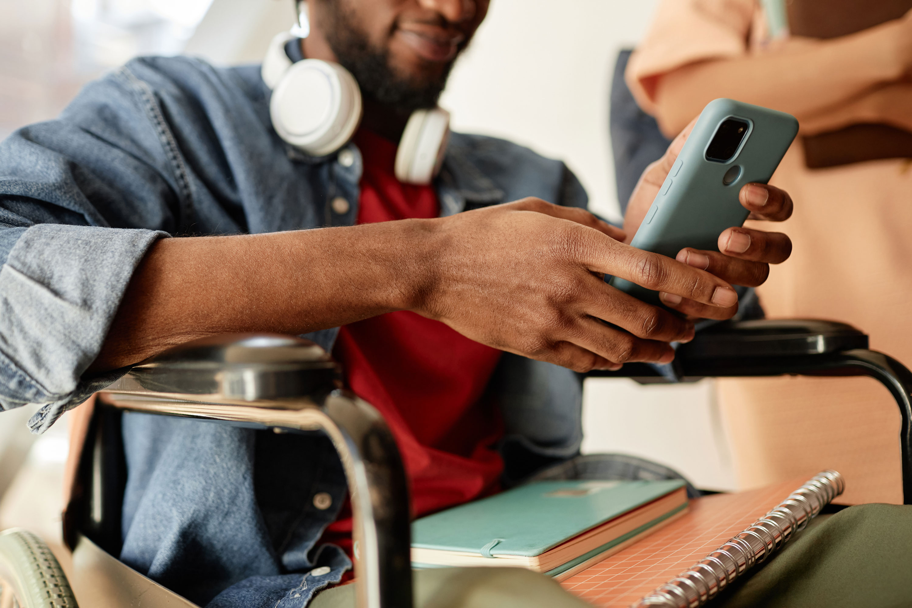 A young man in a wheelchair using his phone