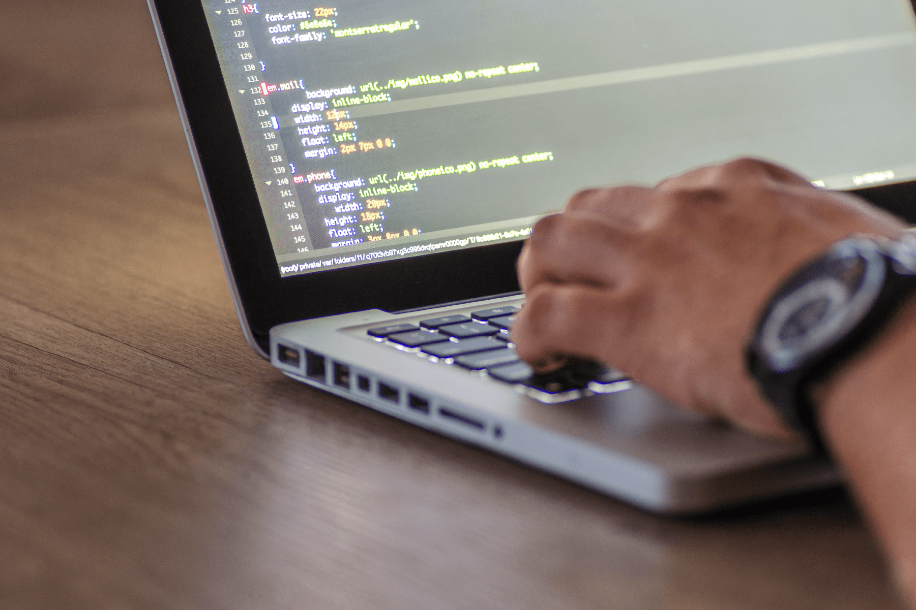 Close up of hand coding on laptop