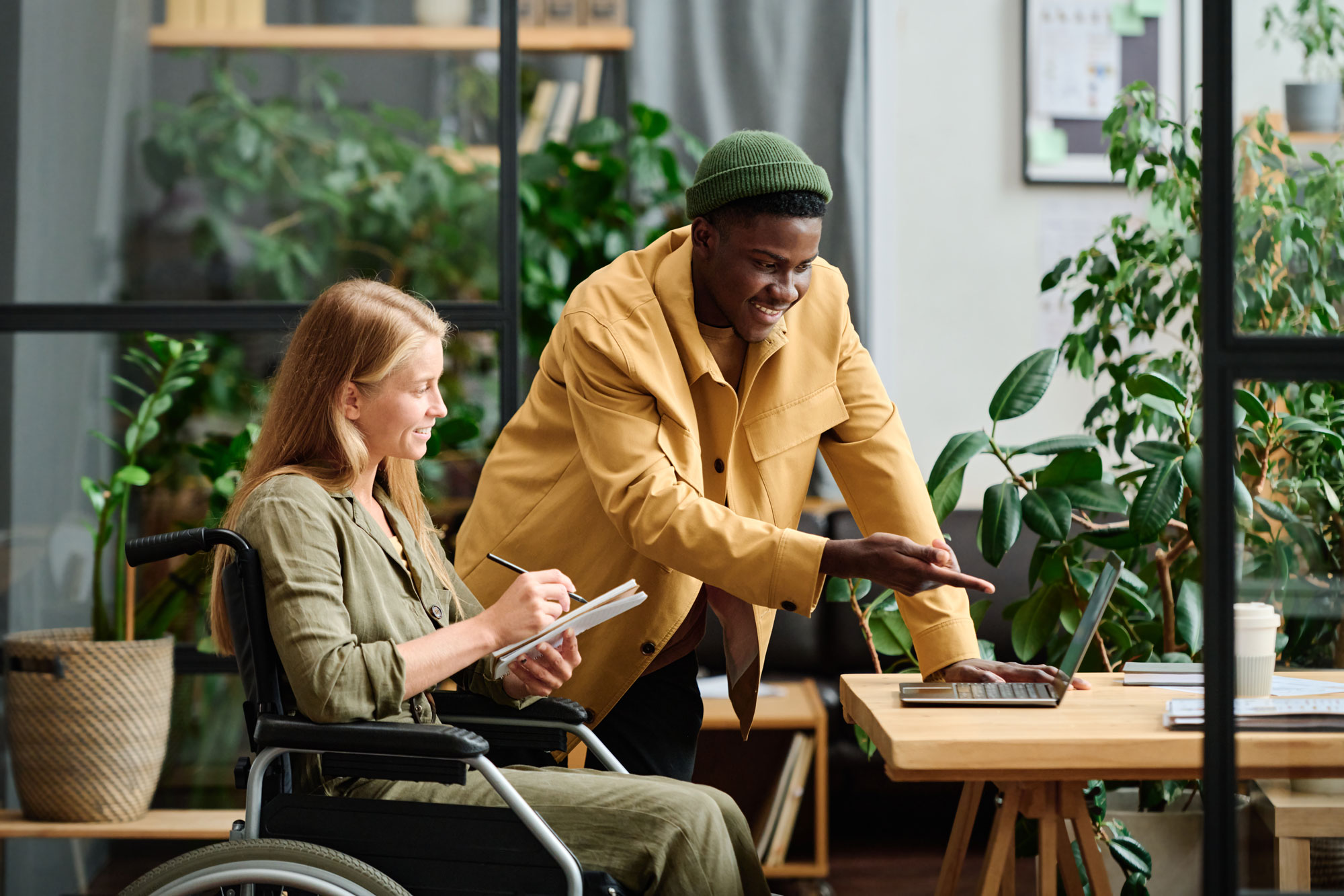 Woman in wheelchair having discussion with man at table.